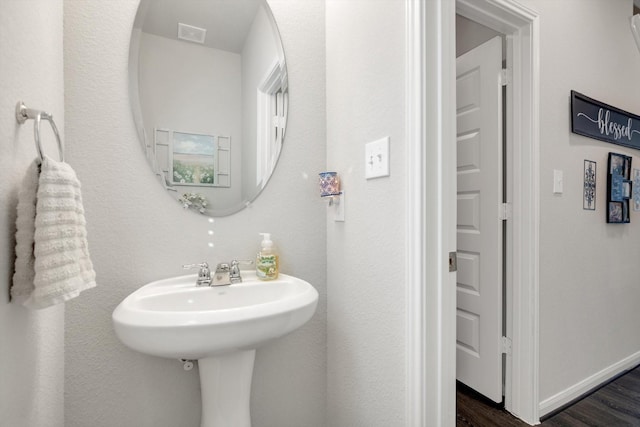 bathroom featuring visible vents, wood finished floors, and baseboards