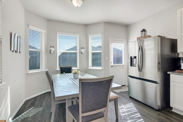 dining area featuring baseboards and dark wood-type flooring