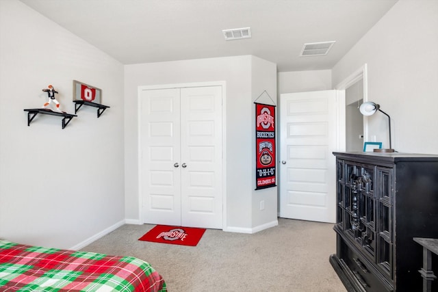 bedroom with carpet flooring, visible vents, and a closet