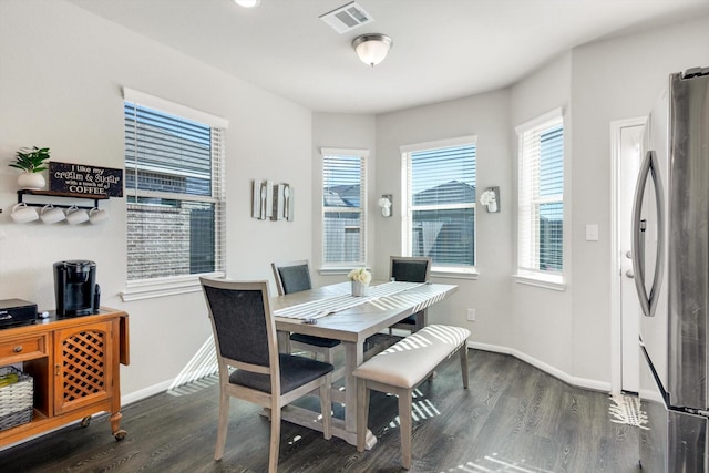 dining room with wood finished floors, visible vents, and baseboards