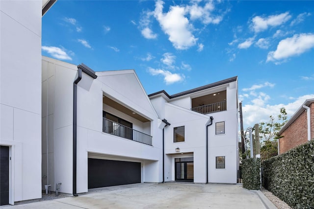 exterior space with stucco siding, concrete driveway, and an attached garage