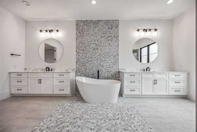 full bathroom with a soaking tub, two vanities, tile walls, and recessed lighting