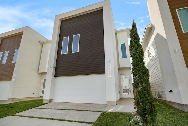 contemporary home featuring stucco siding, concrete driveway, and a garage