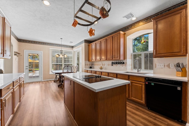 kitchen featuring dark wood finished floors, a sink, black appliances, light countertops, and a chandelier