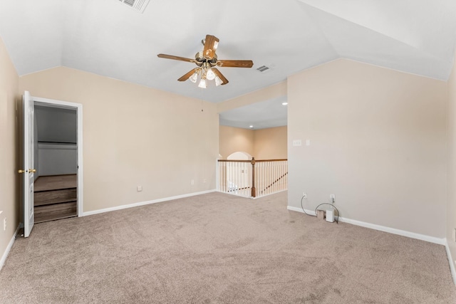 unfurnished room featuring carpet floors, baseboards, a ceiling fan, and vaulted ceiling