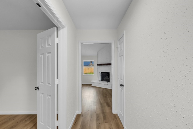 hallway featuring baseboards and wood finished floors