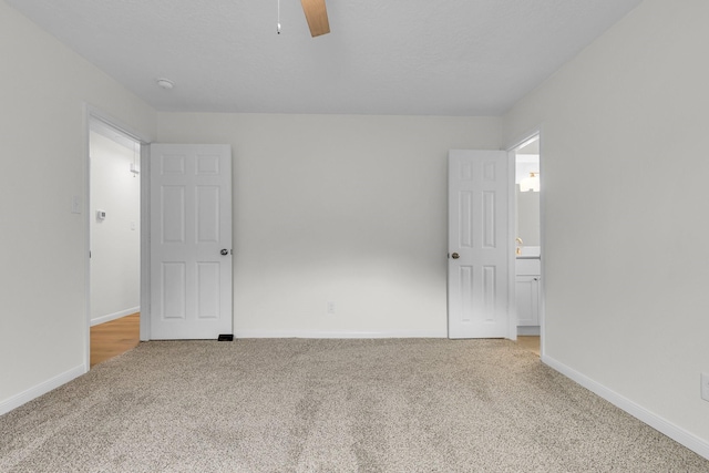 unfurnished bedroom featuring carpet flooring, a ceiling fan, and baseboards