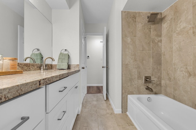 bathroom with vanity, visible vents, washtub / shower combination, and baseboards