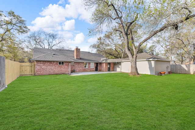 rear view of property featuring a patio, a fenced backyard, a lawn, and driveway