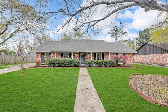 ranch-style home featuring brick siding, a shingled roof, a front lawn, and fence