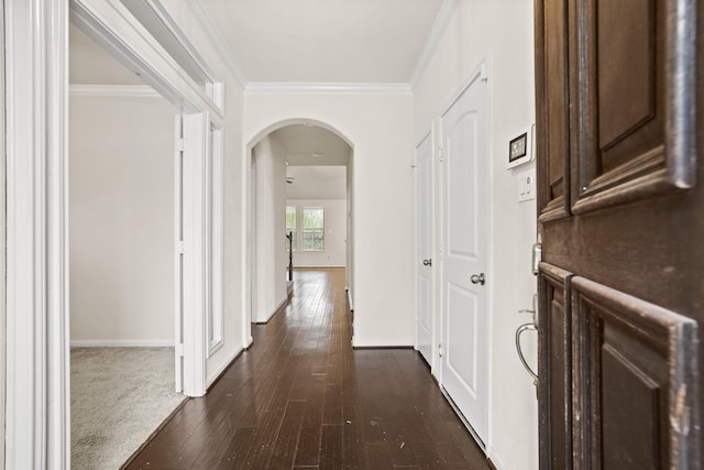 corridor featuring arched walkways, crown molding, and dark wood-style flooring