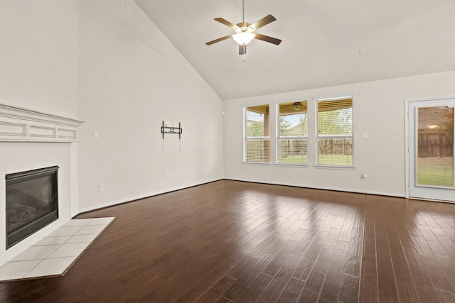 unfurnished living room featuring a ceiling fan, high vaulted ceiling, wood finished floors, and a tile fireplace