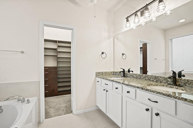 bathroom featuring double vanity, tile patterned flooring, a bath, and a sink