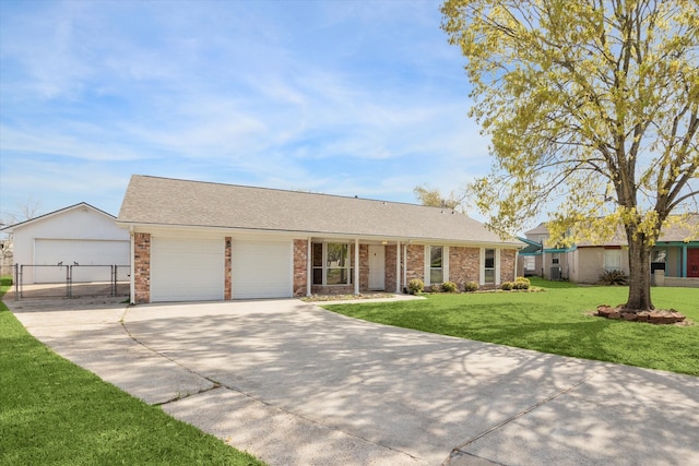 ranch-style home with brick siding, a garage, a front yard, and driveway