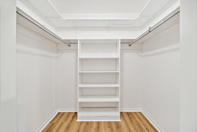 walk in closet with light wood finished floors