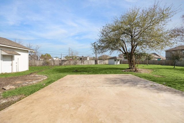 view of yard featuring a patio, an outbuilding, and a fenced backyard