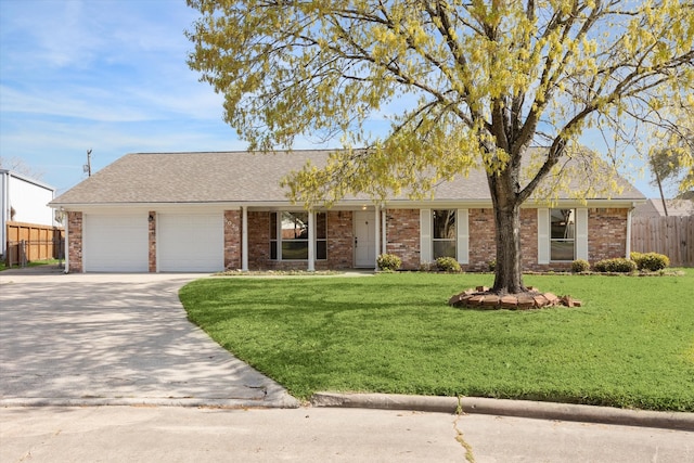 ranch-style home featuring a front yard, fence, a garage, and driveway