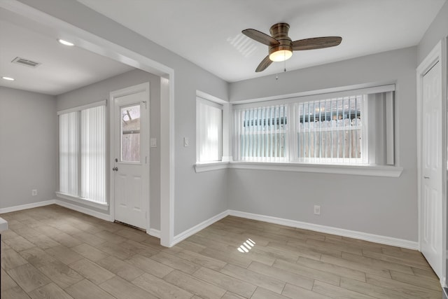 foyer featuring light wood finished floors, visible vents, ceiling fan, and baseboards