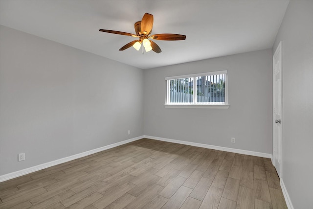 empty room with ceiling fan, baseboards, and wood finished floors