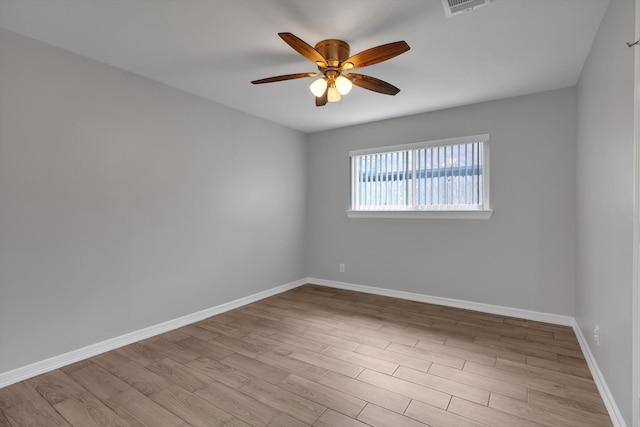 spare room with a ceiling fan, wood finished floors, and baseboards