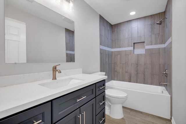 bathroom featuring vanity, wood finished floors, toilet, and washtub / shower combination