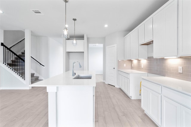 352 Spruce Oak Ln, Waller, TX 77484 - kitchen with a sink, light wood-type flooring, a center island with sink, tasteful backsplash, and recessed lighting