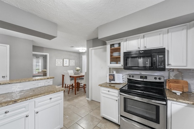 kitchen featuring tasteful backsplash, white cabinets, electric stove, and black microwave