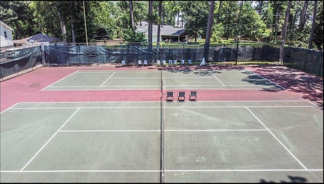 view of tennis court with community basketball court and fence