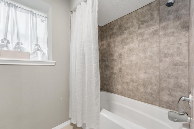 bathroom with baseboards and shower / bath combination with curtain