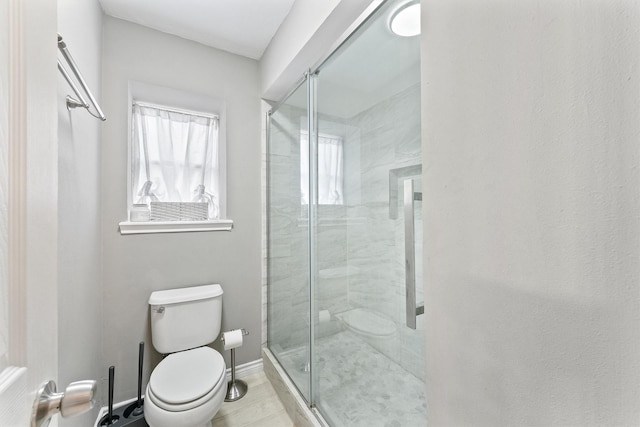 full bath featuring a stall shower, toilet, and baseboards