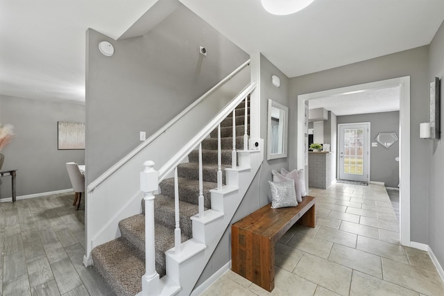 stairway featuring baseboards and tile patterned flooring