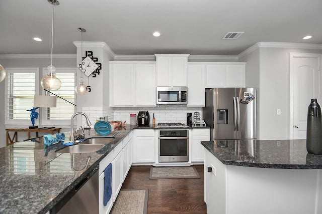 kitchen with visible vents, dark wood-type flooring, a sink, tasteful backsplash, and appliances with stainless steel finishes