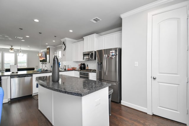 kitchen with visible vents, a sink, dark wood finished floors, appliances with stainless steel finishes, and a peninsula