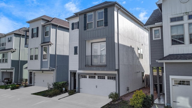 townhome / multi-family property featuring concrete driveway, a shingled roof, and a garage