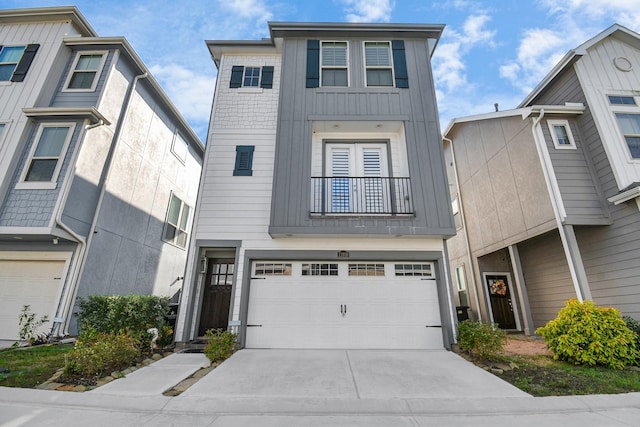 view of property with concrete driveway, a balcony, an attached garage, and board and batten siding