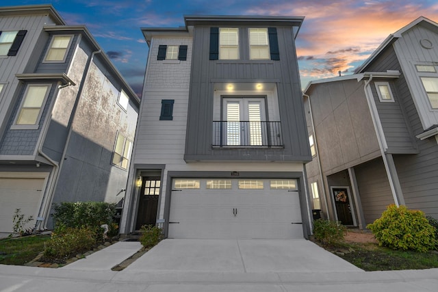 view of front of property featuring a garage, a balcony, board and batten siding, and concrete driveway