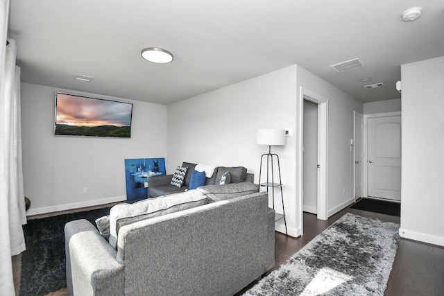 living room featuring visible vents, baseboards, and dark wood-type flooring