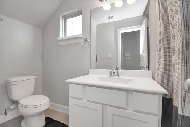 bathroom featuring vanity, baseboards, visible vents, vaulted ceiling, and toilet