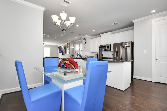 dining space with dark wood-style floors, an inviting chandelier, ornamental molding, and visible vents