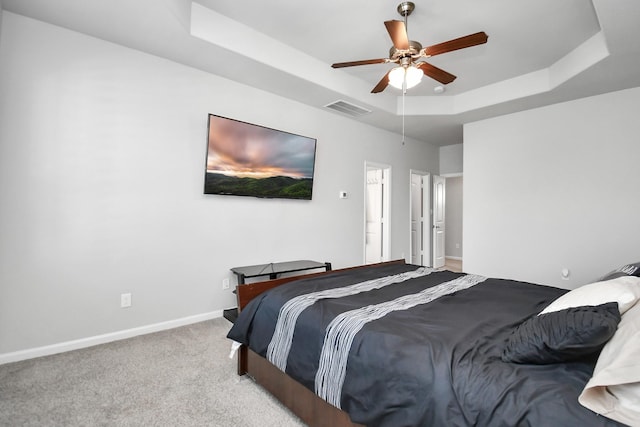 bedroom featuring visible vents, baseboards, carpet, a raised ceiling, and ceiling fan