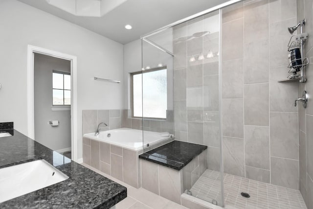 bathroom with recessed lighting, a shower stall, vanity, and a garden tub