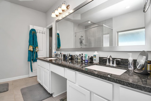 bathroom featuring tile patterned floors, a stall shower, double vanity, and a sink