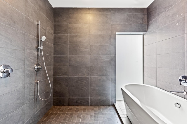 full bathroom featuring a soaking tub and tiled shower