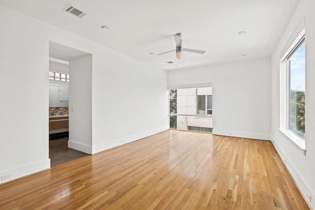 unfurnished room featuring visible vents, light wood-style flooring, baseboards, and ceiling fan