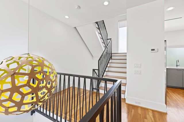 staircase with recessed lighting, baseboards, and wood finished floors