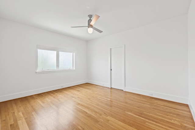 spare room with light wood-style flooring, a ceiling fan, and baseboards