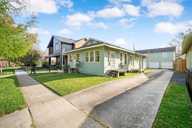 view of side of home with stucco siding, driveway, a yard, and fence