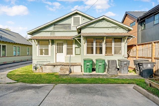 view of front of property with fence and a shingled roof