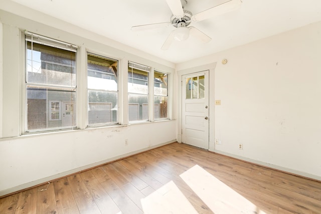 unfurnished sunroom featuring ceiling fan