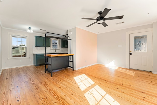 interior space with green cabinetry, light wood-style flooring, ceiling fan, wood counters, and tasteful backsplash